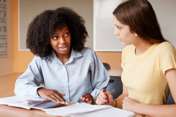 istock High School Tutor Giving Female Student One To One Tuition At Desk 999246334