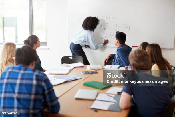 Female High School Tutor At Whiteboard Teaching Maths Class Stock Photo - Download Image Now