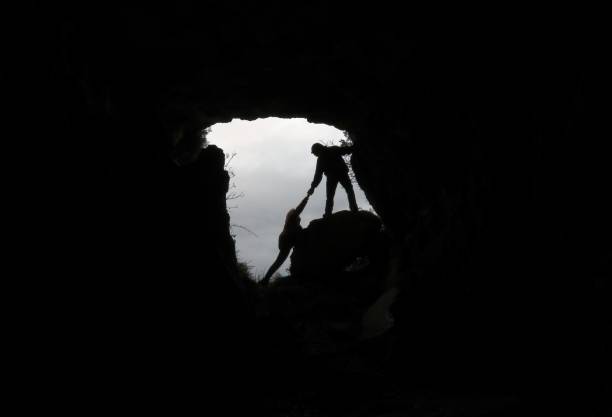 洞窟の中で人を救う男 - rock climbing 写真 ストックフォトと画像