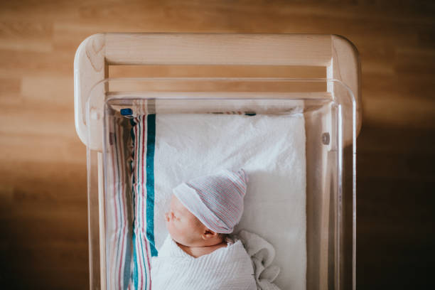 bébé dort dans la couchette de l’hôpital - nouveau né photos et images de collection