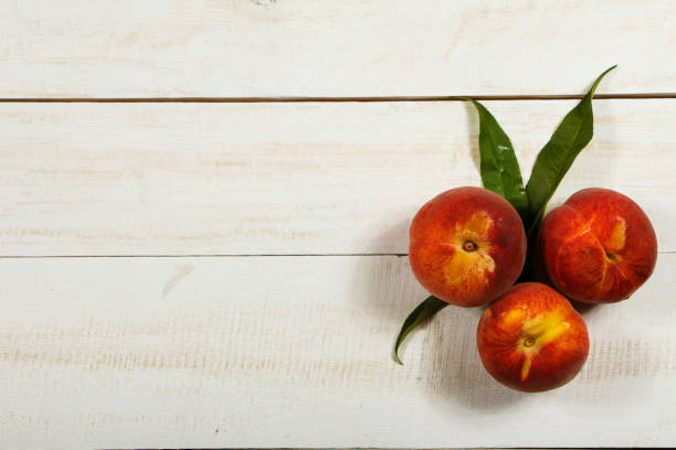 istock Peach fresh juice with fresh peaches on a white background. Top view, copy space. Fresh juice with peach. Healthy eating. 999313082
