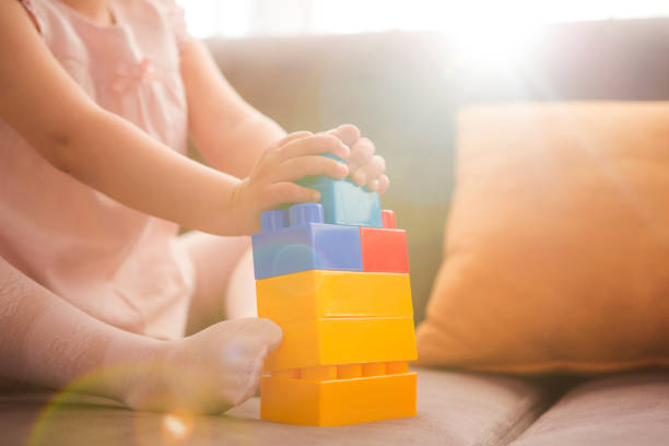istock Little girl playing with toy blocks 999316414