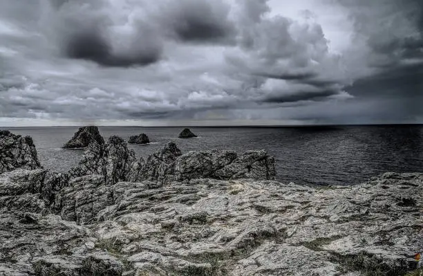 storm wolken met ruwe rotsen en donkere zee