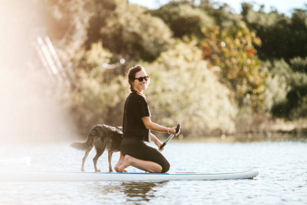 Woman On Paddleboard With Pet Dog