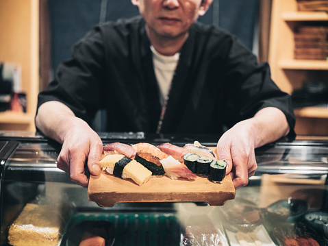 A sushi chef working in a small shop in Tokyo, Japan.