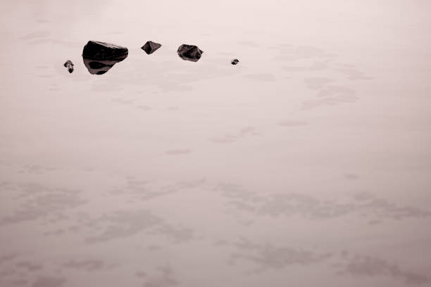 Small boulders in a pool of water left by receding tide on the Porthmeor beach at dusk, Cornwall, England, UK, Europe