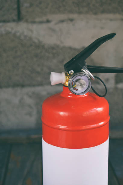 istock Compact red fire extinguisher for auto or home on grey background. For fire emergencies. 999350586