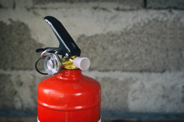 istock Compact red fire extinguisher for auto or home on grey background. For fire emergencies. 999360898