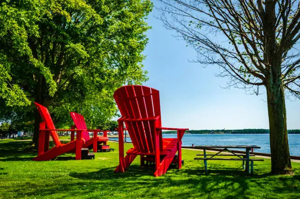 Photo of Three giant red adirondack chairs at Brockville overlooking the Thousand Islands, and St. Lawrence River