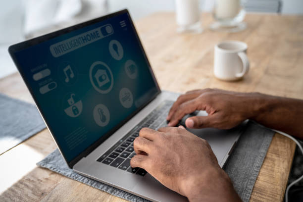 istock Man setting up the intelligent home system on his laptop 999411366