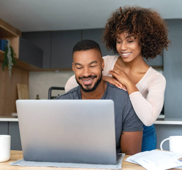 istock Black couple paying bills online at home 999411394