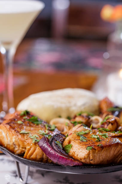 Salmon with rock onion, squid, tomatoes and ciabata bread served in the rechaud