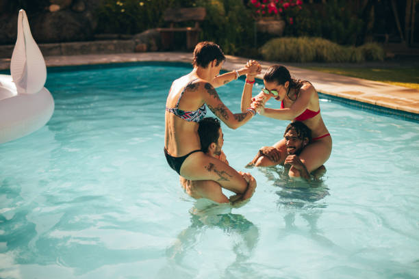 istock Friends having fun in the holiday resort pool 999480612