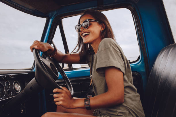 istock Woman on road trip having fun driving a car 999492590