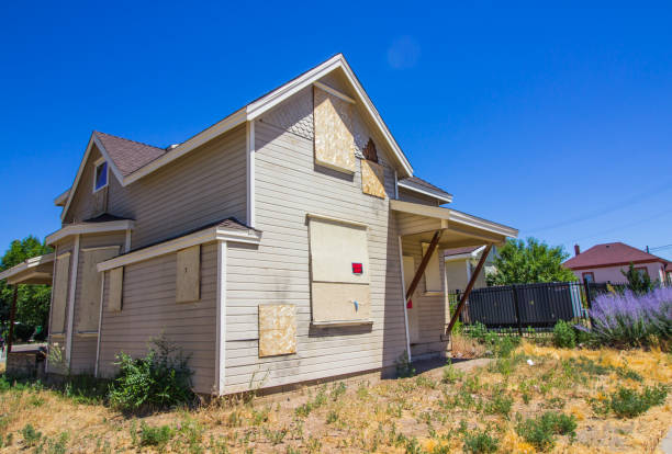 Abandoned Two Story Building Abandoned Two Story Home With Boarded Up Doors & Windows drab stock pictures, royalty-free photos & images
