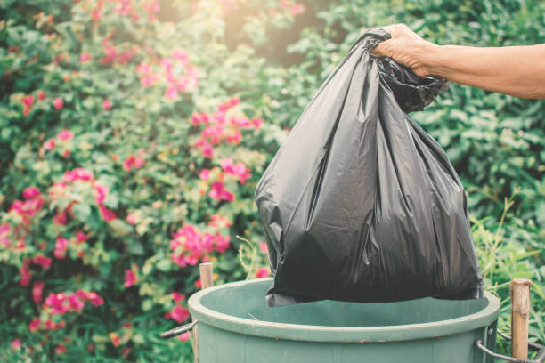 istock Cropped Hand Holding Garbage Bag Over Can 999552590