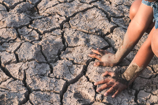 istock High Angle View Of Boy Crouching On Barren Field 999554206