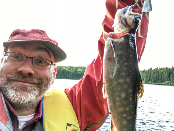 istock Fisherman hold proudly a trout he just caught during day 999635632
