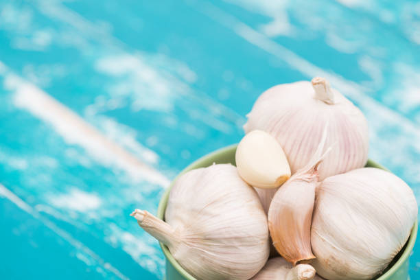 istock Garlic on green wood background 999635850