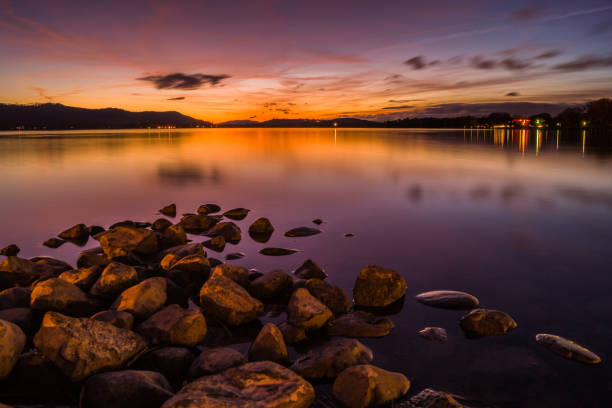 An abstract image of a peaceful moomaw lake in the evening. There are strange formations of clouds in the sunset sky.  The mountains (from the Gathright Wildlife Management Area) are rising up to meet the clouds.  It is part of  the George Washington and Jefferson National Forest. Copy space.