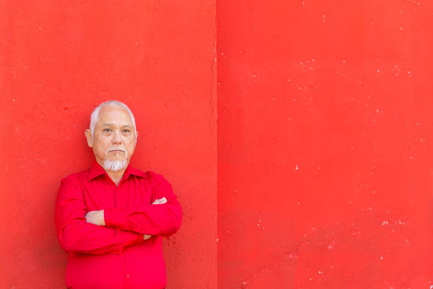 istock Asian man standing in front of red colored wall 999666828