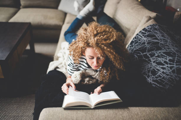 istock Young woman reading at home 999672920