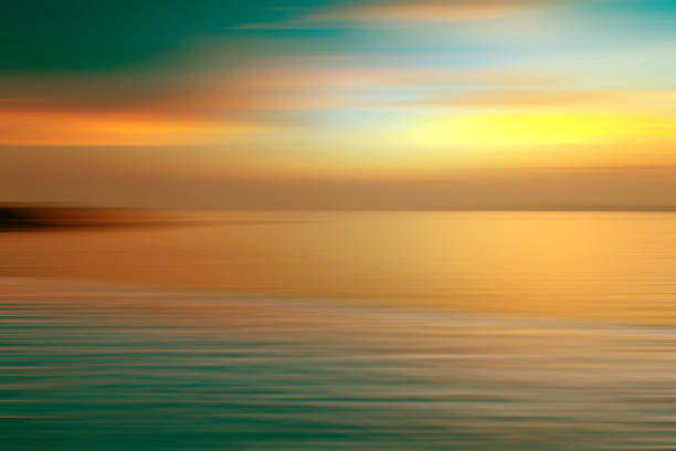 istock Motion blurred background of refraction in water. Panoramic dramatic view of Infinity sunset on the sea at twilight times 999681318