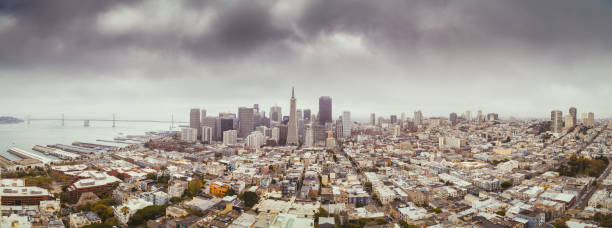 Classic aerial view of modern San Francisco skyline in summer with famous San Francisco fog rolling in seen from historic Coit Tower with retro vintage filter effect, San Francisco Bay Area, California, USA