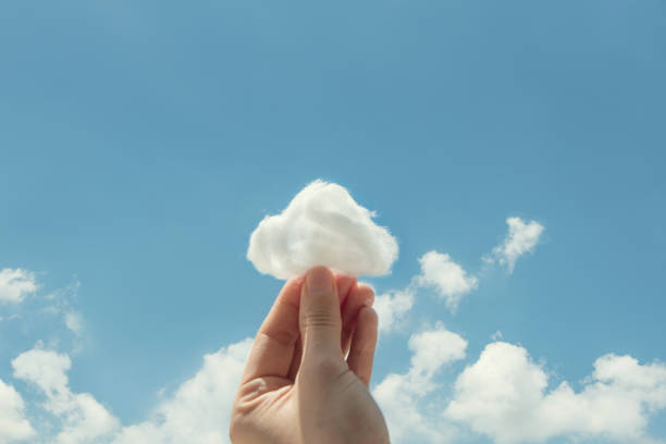 istock Woman hand holding cotton wool on cloud sky background. 999682830