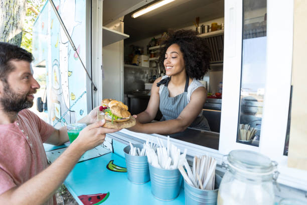 istock Male customer taking sandwiches from food van 999687214
