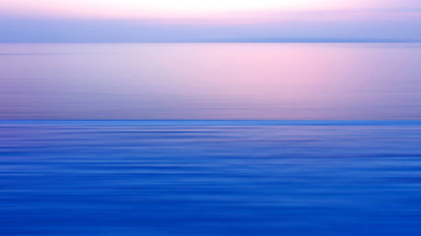 istock Motion blurred background of refraction in water. Panoramic dramatic view of Infinity sunset on the sea at twilight times 999688684