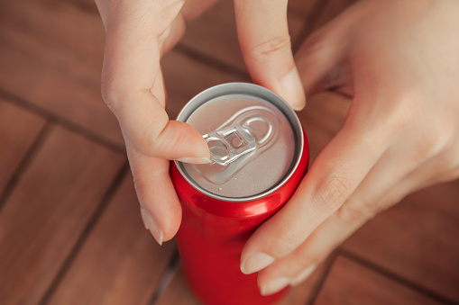 Female opening a can of tin