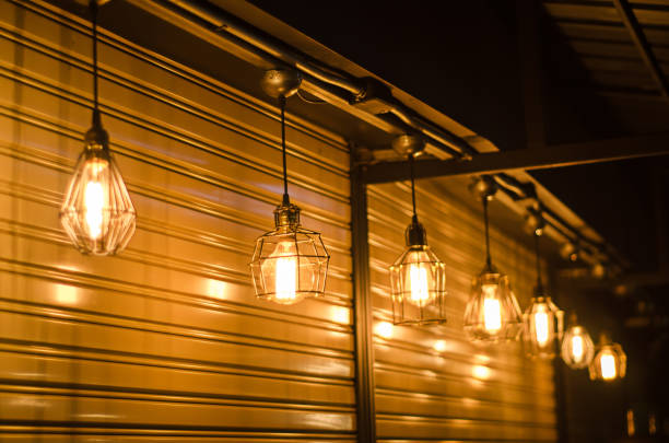 istock Low Angle View Of Illuminated Light Bulbs Hanging At Night 999723540