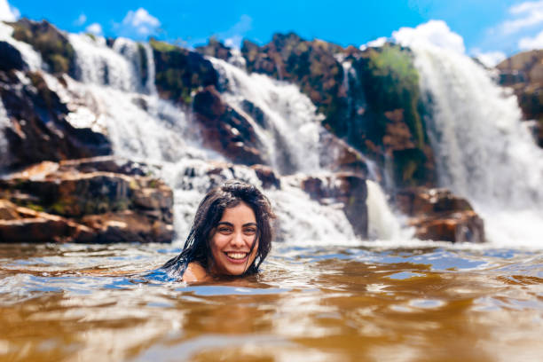 Young woman enjoying the Cascade of Leathers, Chapada dos Veadeiros Young woman enjoying the Cascade of Leathers, Chapada dos Veadeiros river swimming women water stock pictures, royalty-free photos & images