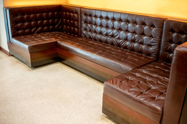 istock Vintage classic brown leather sofa on white floor against yellow background. Interior design concept. 999757984