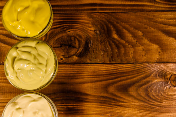 istock Different sauces in glass bowls on wooden table. Top view 999767102