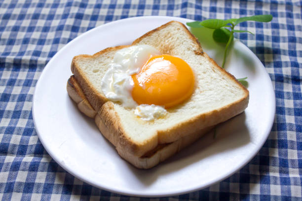 Close up shot avocado toast with a fried egg and cherry tomato