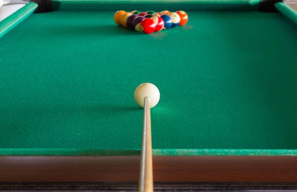 istock Pool table and balls set with the cue stick aiming white cue ball 999788278