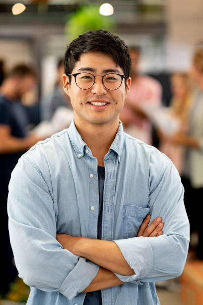 istock Asian man at a creative office with a group at the background 999791082