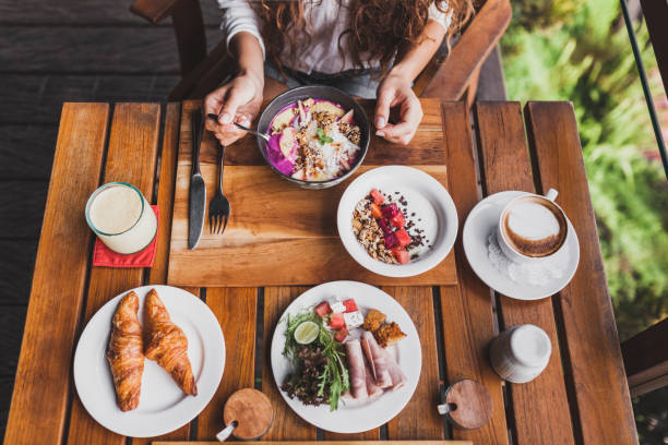 istock Woman hands holding spoon and having breakfast, view from above 999791540
