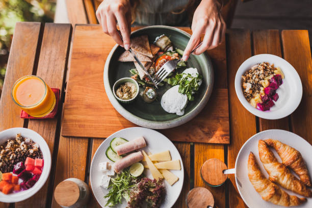 istock Woman hands holding fork and knife and having breakfast, view from above 999791542