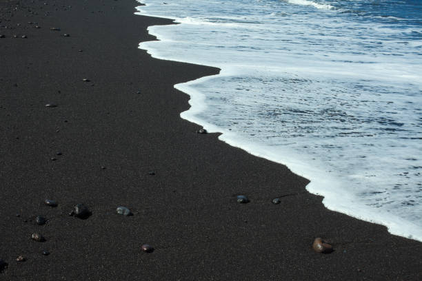 istock Black sand beach with white ocean foam 999791970