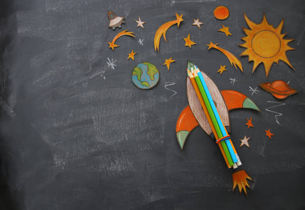 istock Back to school concept. rocket, space elements shapes cut from paper and painted over class room blackboard background. 999792166