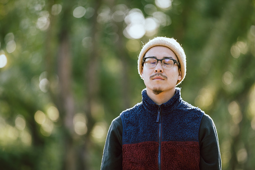 Portrait of an Asian men who put on glasses at the park