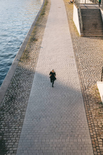 istock Woman running on a sunny evening by the river. 999805616