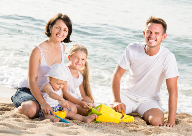 istock Positive family with children playing at beach 999812326