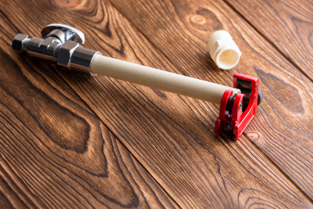 plumber cuts off a polypropylene pipe for plumbing installation, close-up.