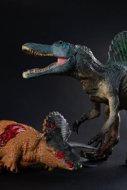 istock spinosaurus with a triceratops body nearby on dark background vertical composition 999830682