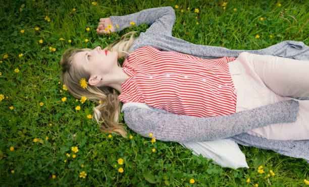 istock Young woman lying on grass. 999848786