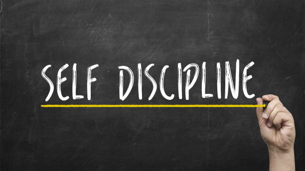 Self discipline concept. Hand writing self discipline inscription text on blackboard. stock photo